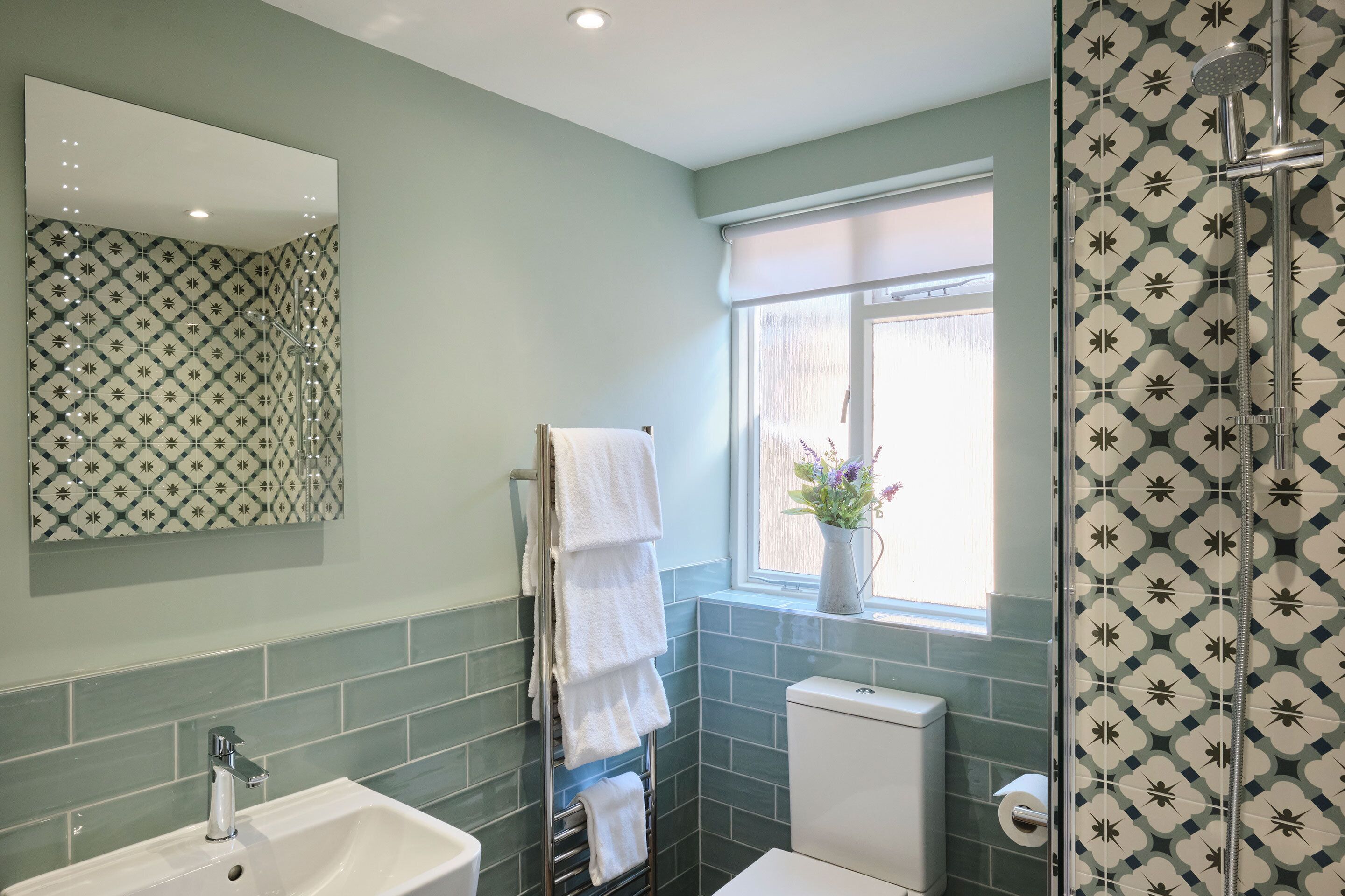 Une salle de bain avec un lavabo, un miroir et une douche.