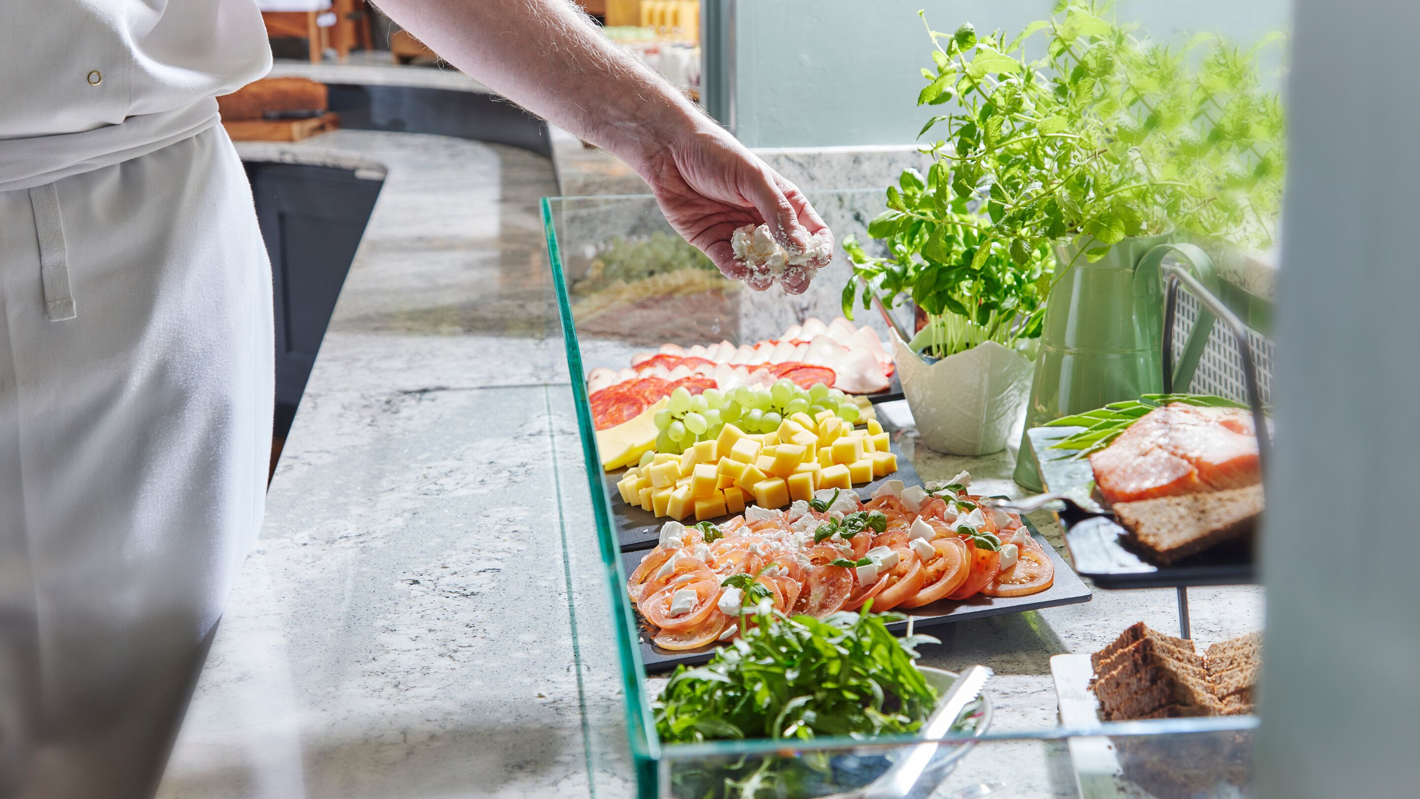 Un bufé con diversas opciones de comida, incluyendo queso, frutas y ensaladas.