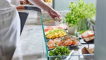 Un bufé con diversas opciones de comida, incluyendo queso, frutas y ensaladas.