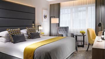 Quarto de hotel moderno com uma cama grande, uma escrivaninha e uma cadeira.