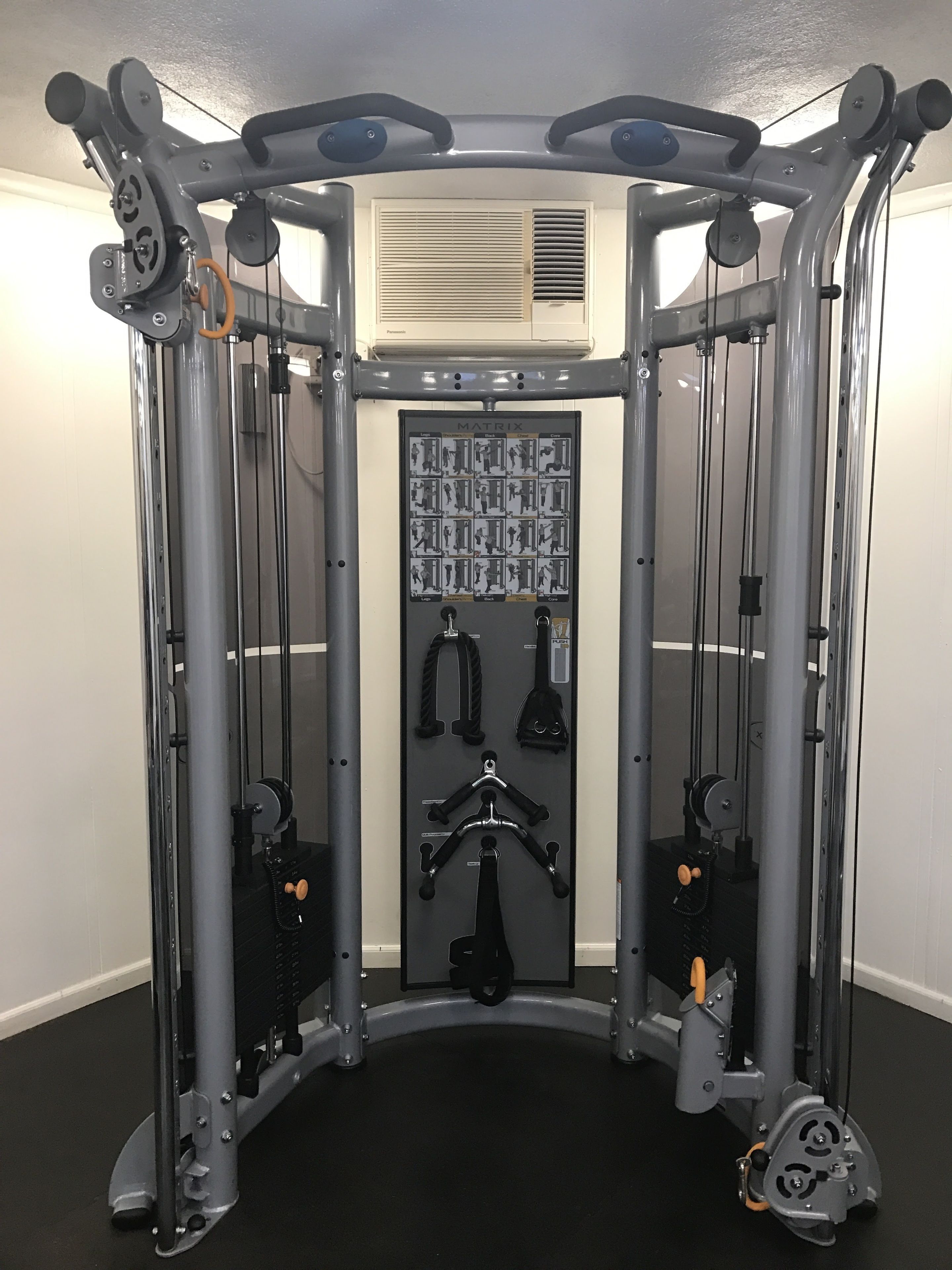 A gym with a pull-up bar, cable machine, and weight stack.