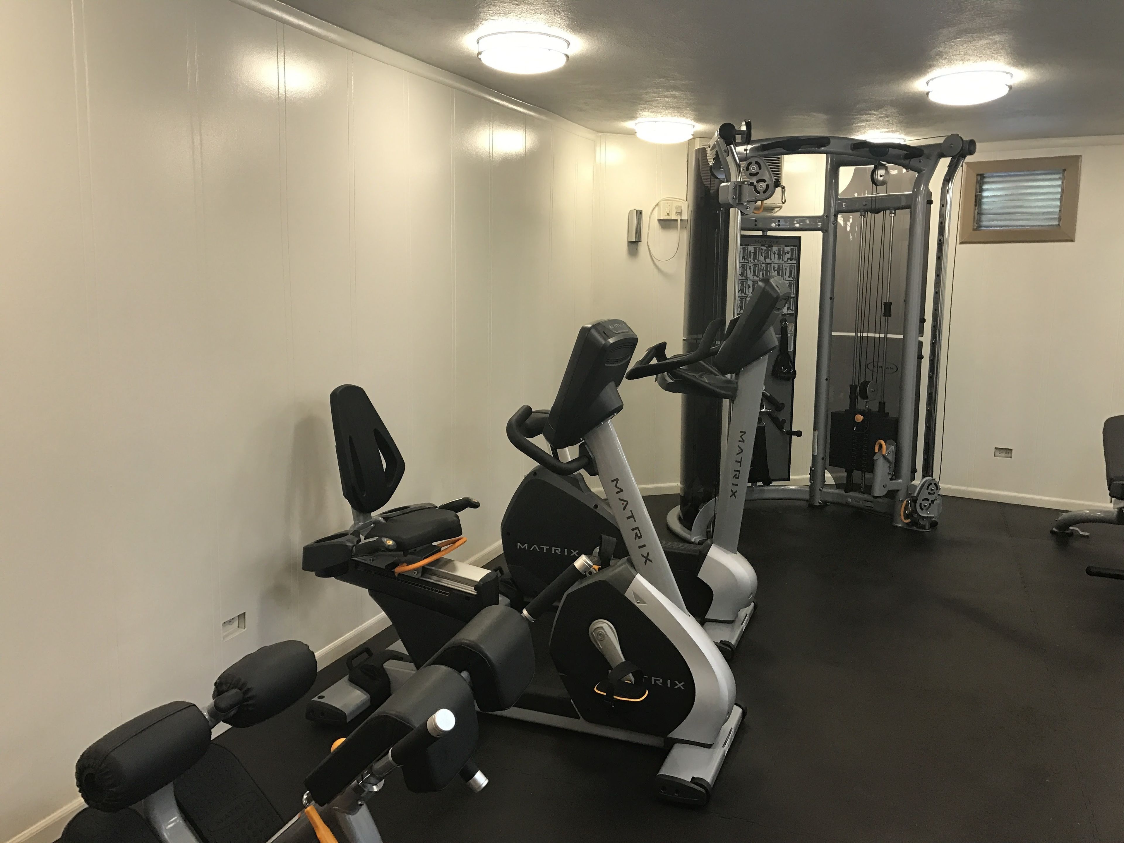 A gym with exercise equipment including treadmills, weight machines, and free weights.