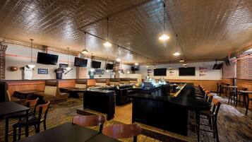 A restaurant with a bar area, booths, and tables.