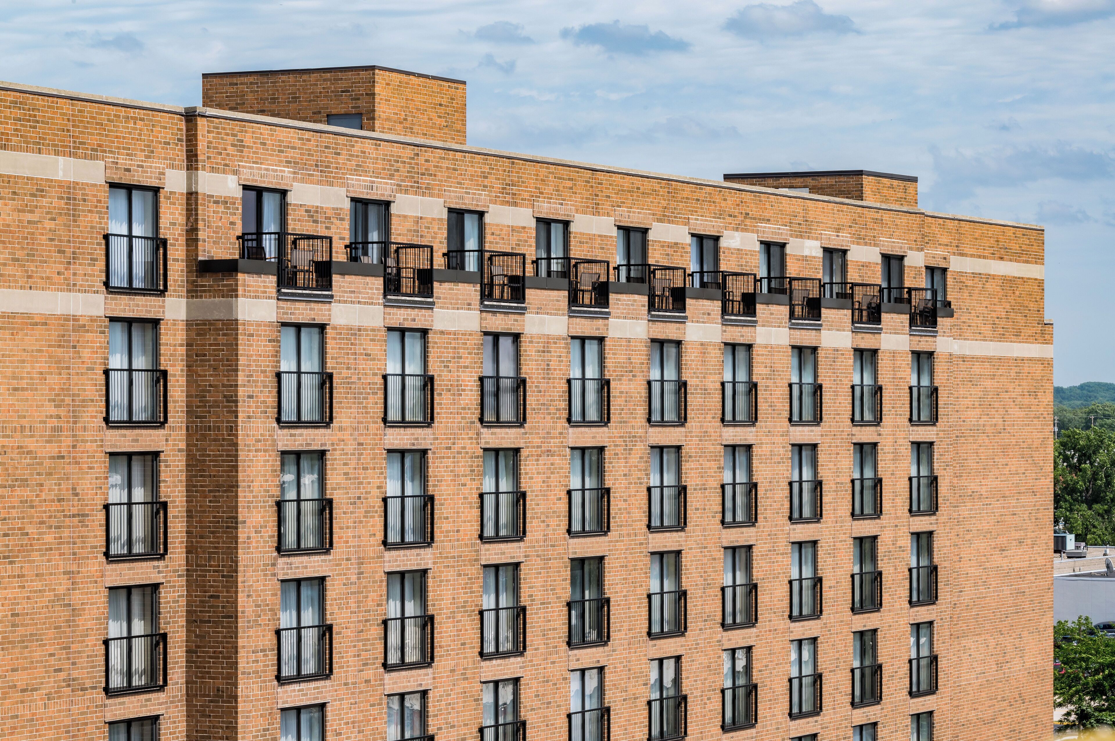 A multi-story brick building with a uniform facade, numerous windows, and balconies.
