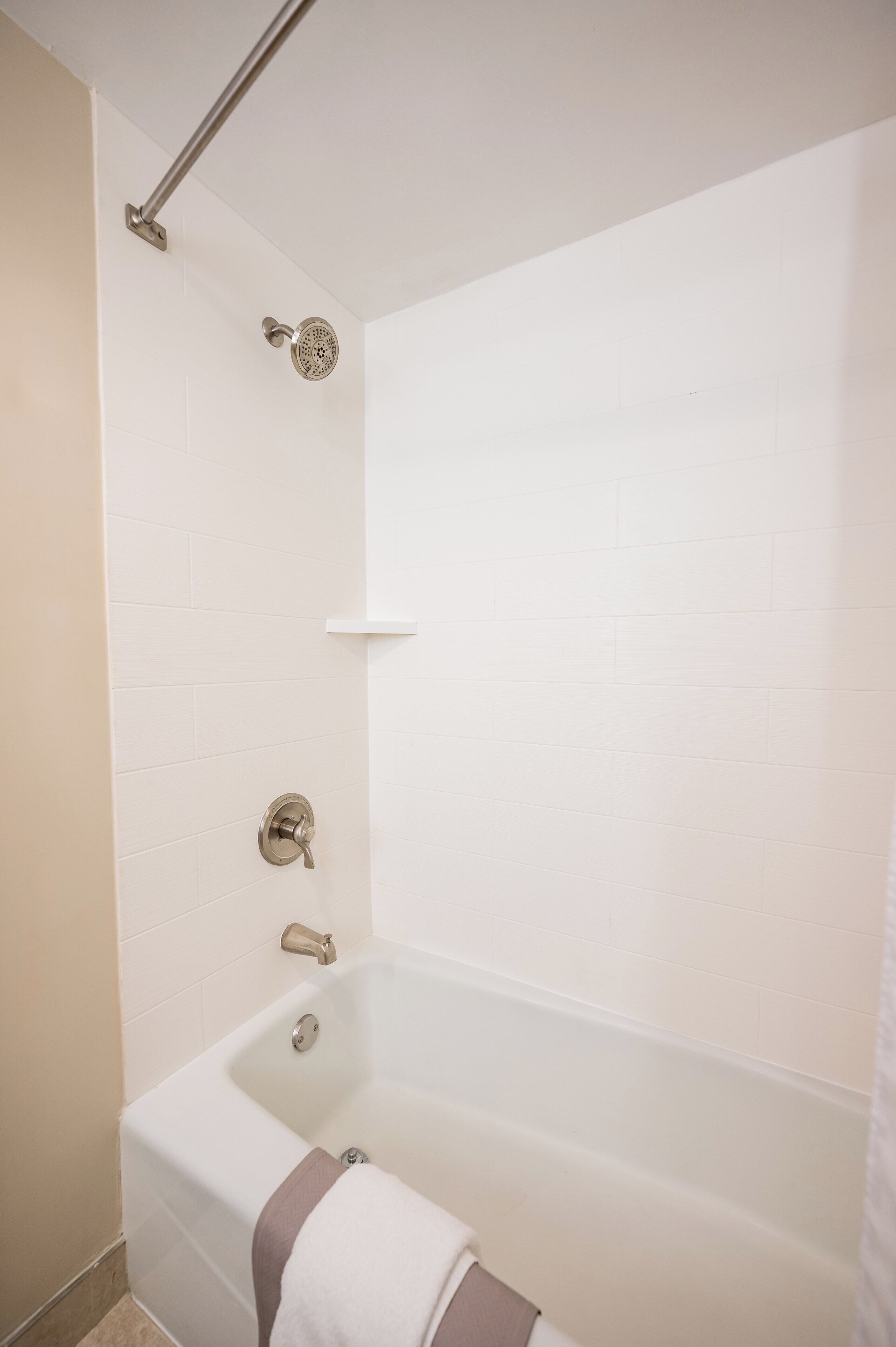 Un baño moderno con bañera, ducha y toallero.