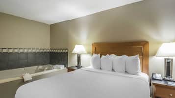 A hotel room with a large bed, a bathtub, and two bedside lamps.