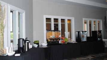 Montaje de bufé con estación de café, fruta y bebidas.