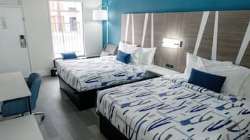 Ein Hotelzimmer mit zwei Betten, einem Schreibtisch und einem Stuhl.