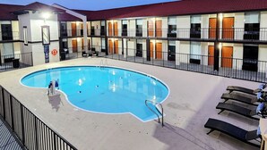 A hotel with a swimming pool, multiple balconies, and a red roof. - Serenity Stay (Chattanooga)