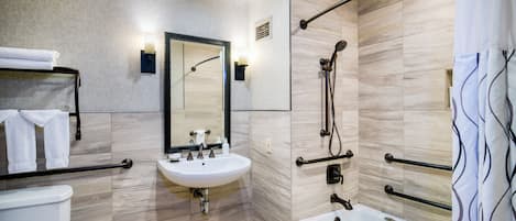Un baño moderno con lavamanos, espejo, inodoro, ducha y bañera.