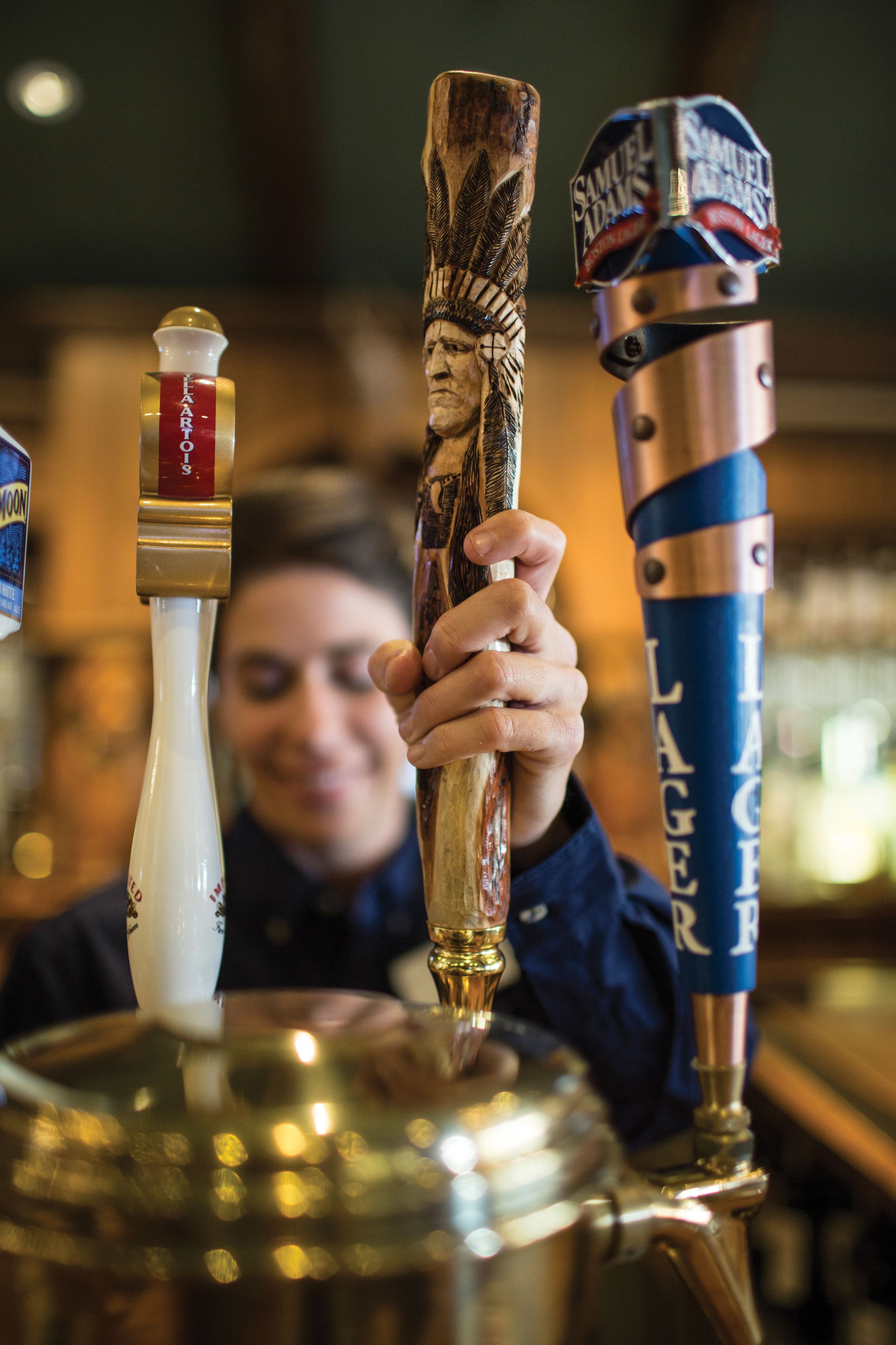 A bar with a tap labeled "Samuel Adams" and a wooden bar tool.