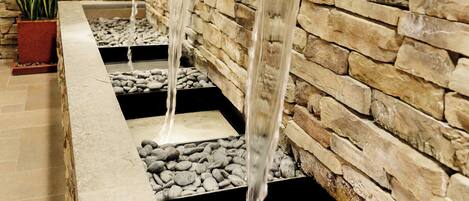 Un muro de piedra con una fuente de agua.