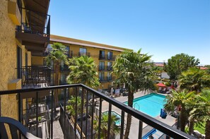 Relax by the pool surrounded by palm trees, accessible via a staircase.