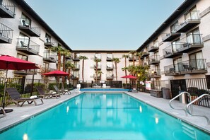 Relax by the serene indoor pool surrounded by lounge chairs and palm trees.