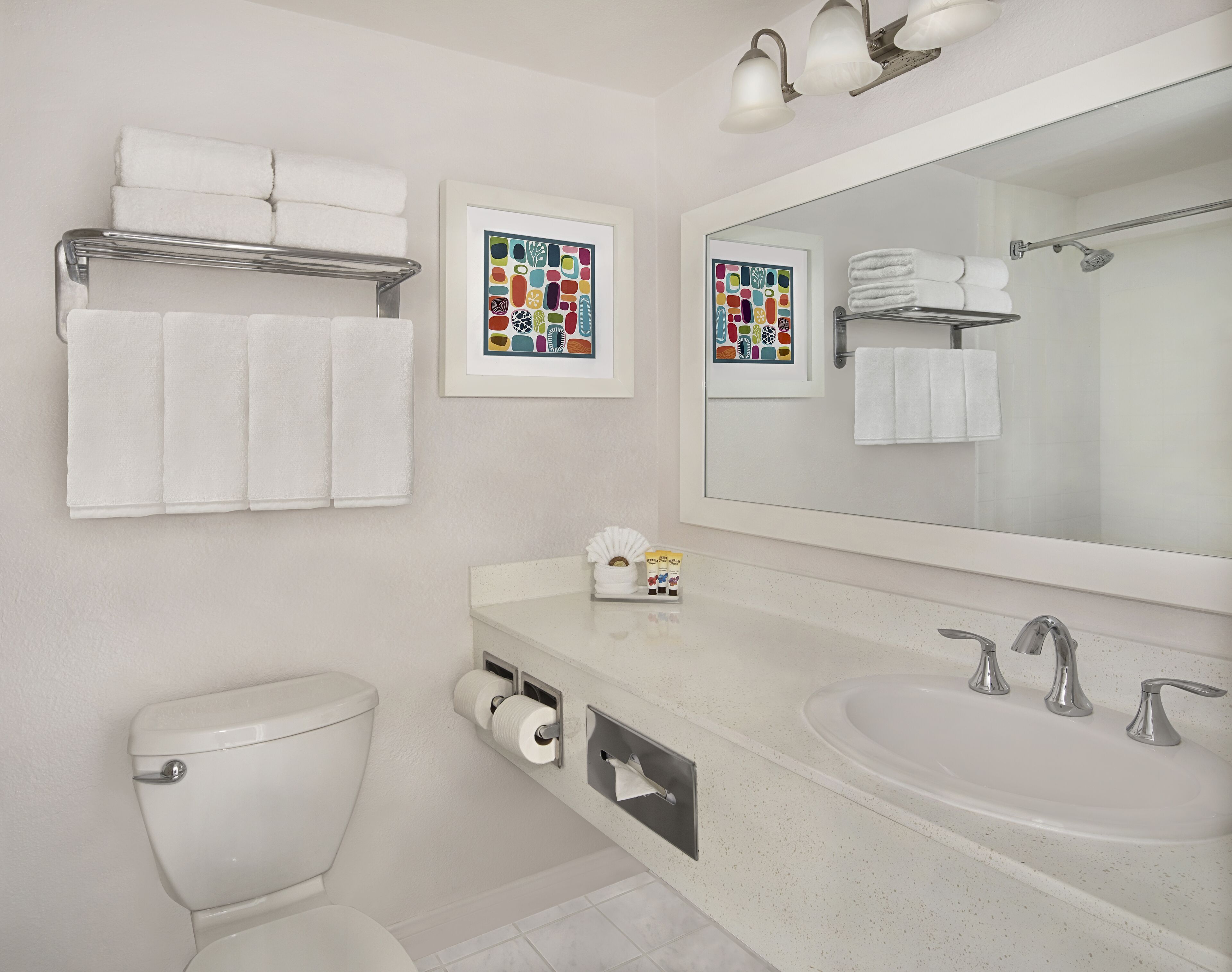 A modern bathroom with a toilet, sink, and towel racks.
