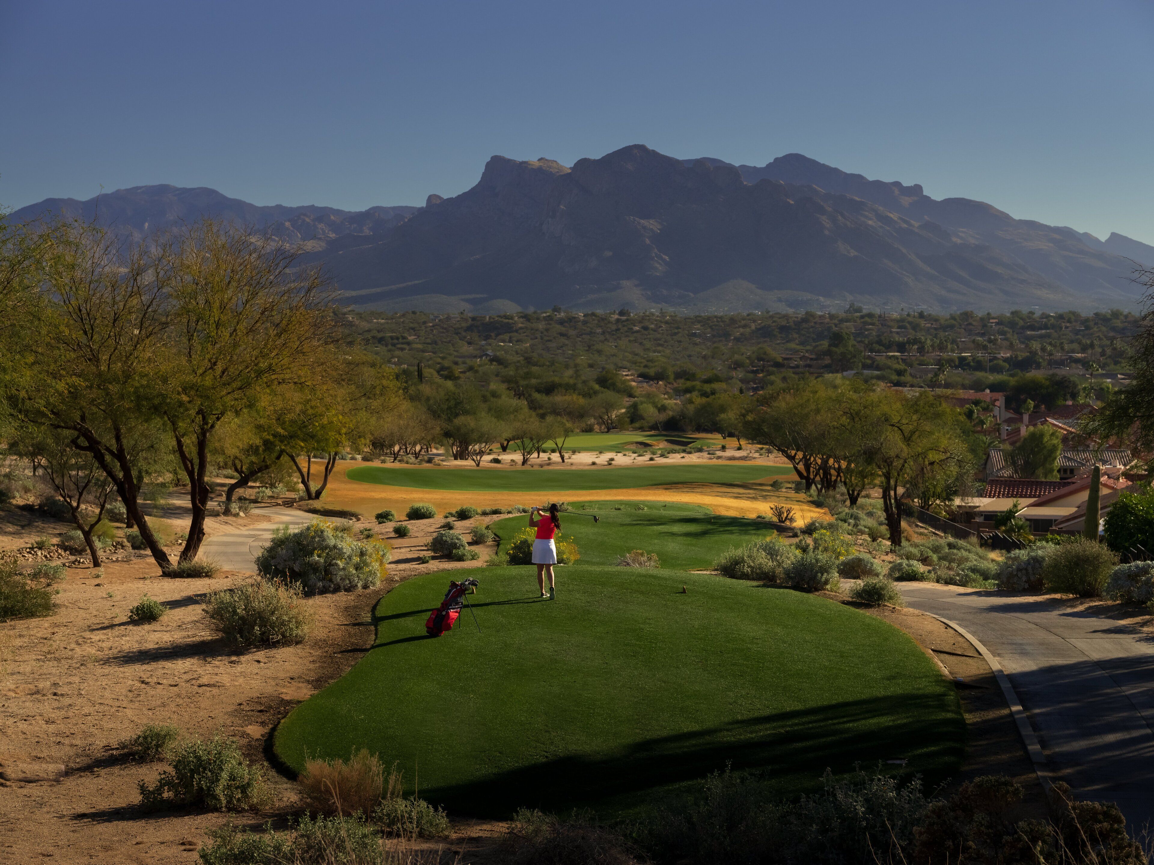 A golf course with a clear view of a mountain range in the background.