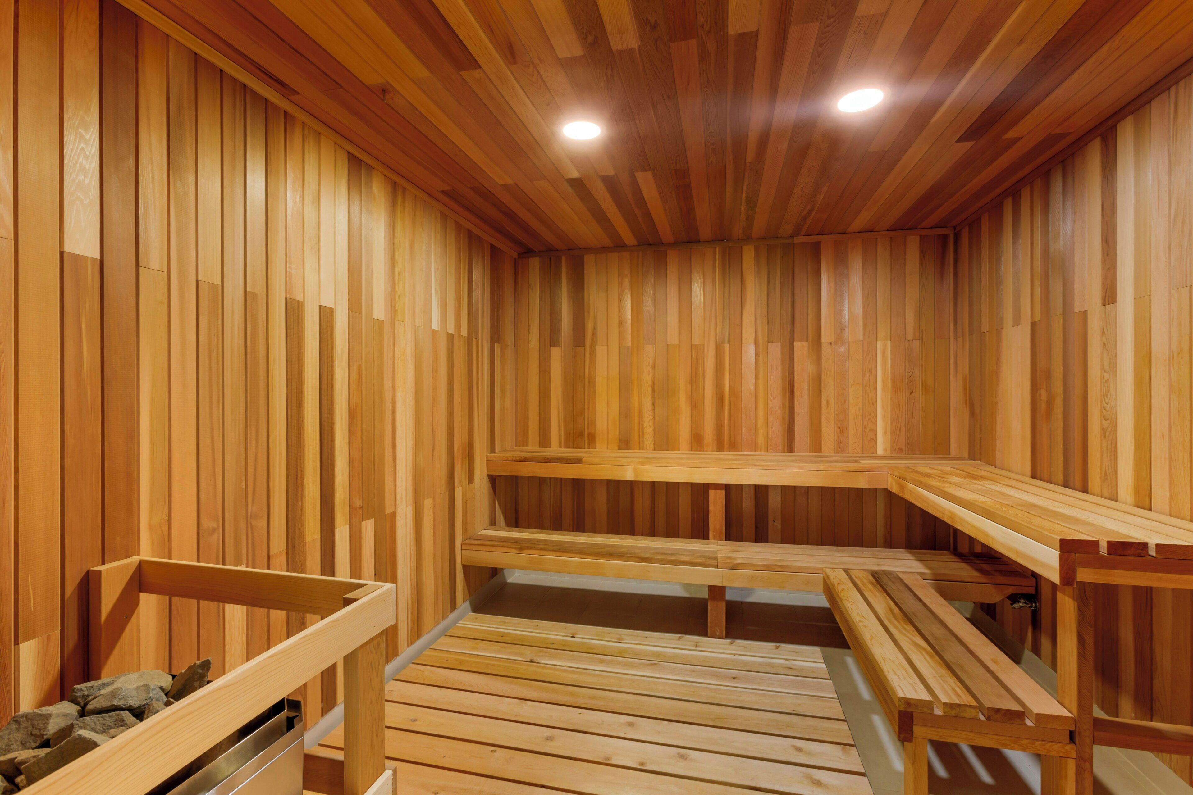 A sauna with wooden benches and a stone bench.