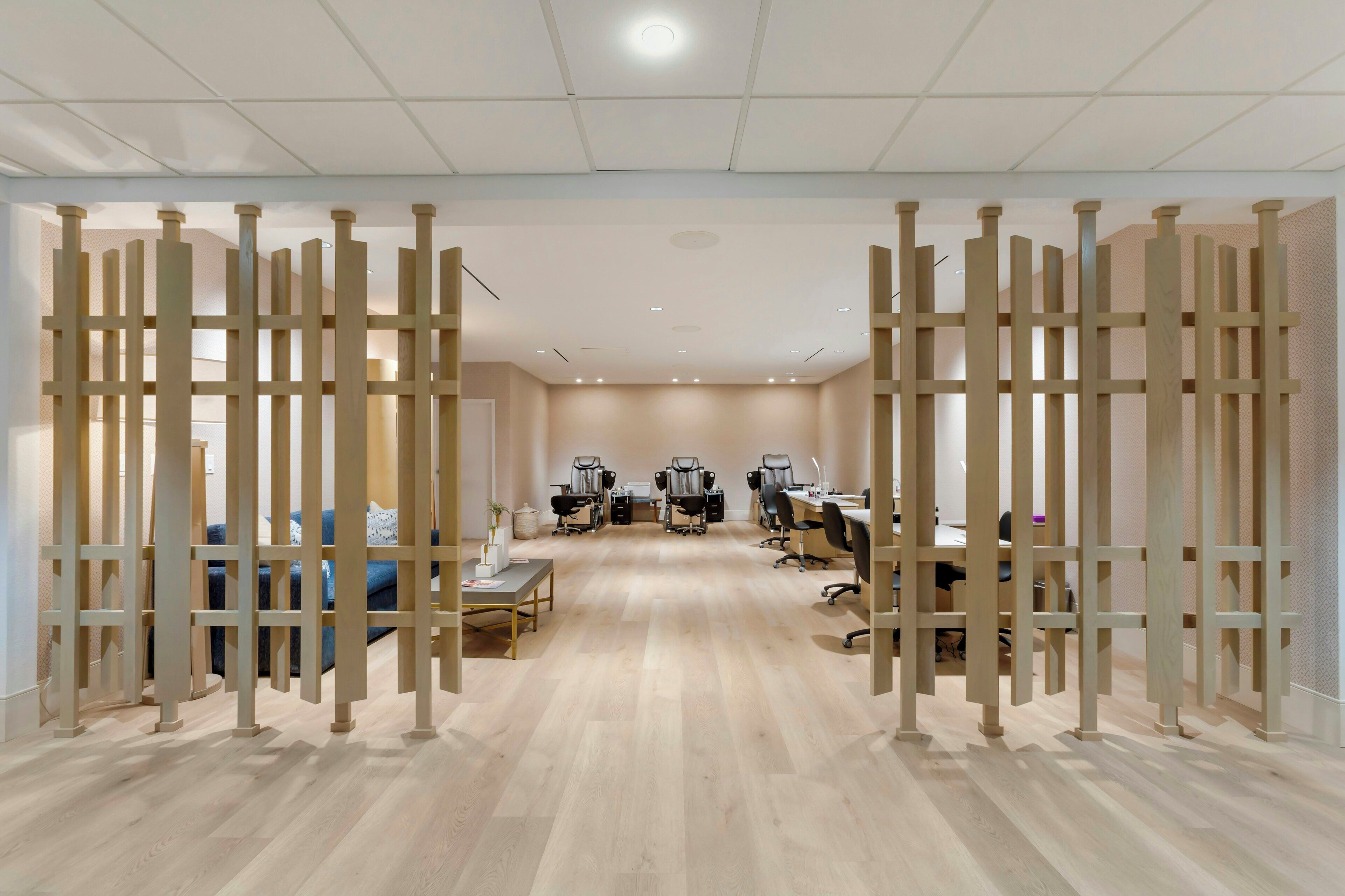 Un espacio de oficina moderno con un área de reuniones central, puestos de trabajo individuales y una recepción.