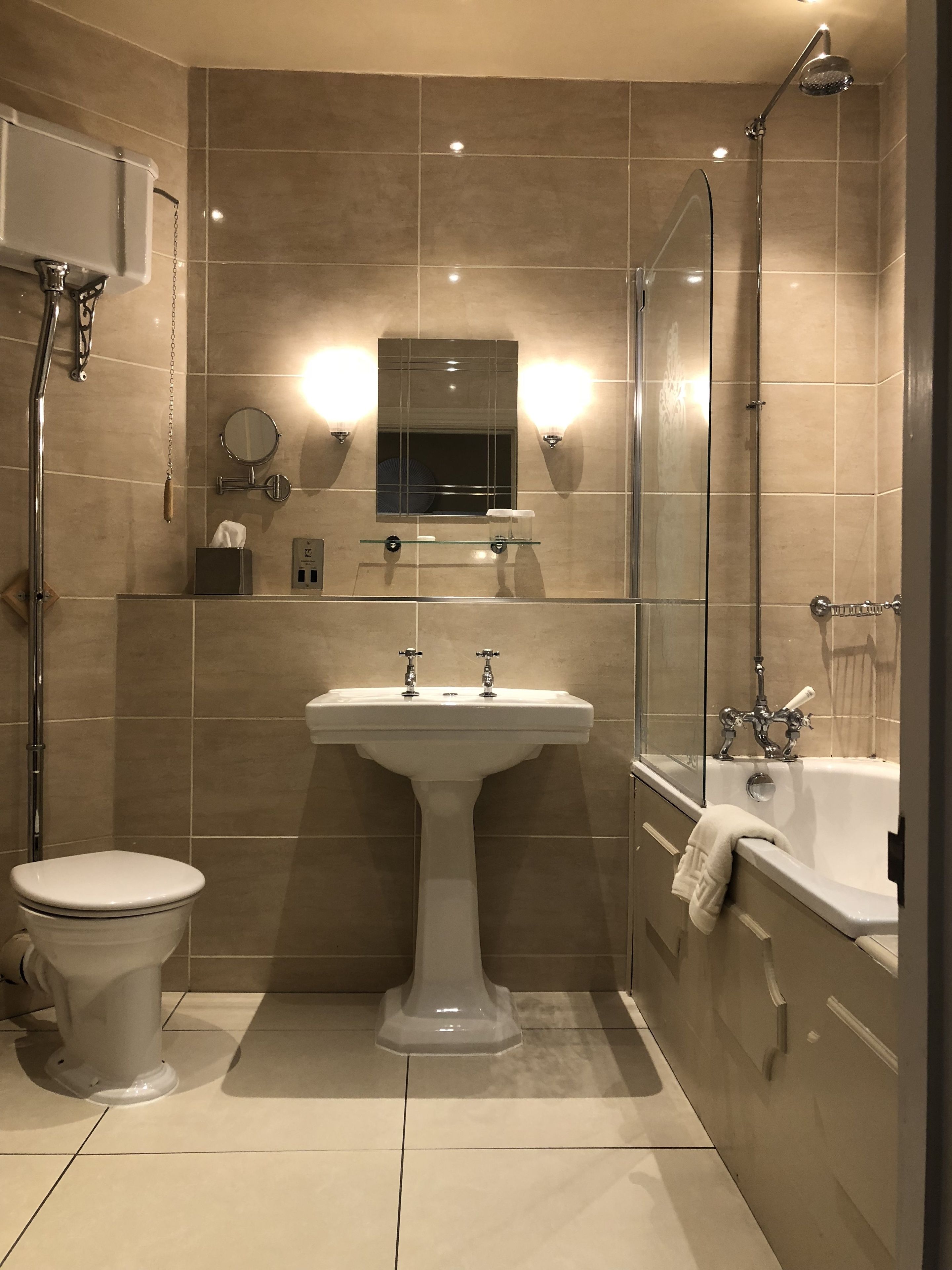 A bathroom with a pedestal sink, a toilet, a bathtub, and a shower.