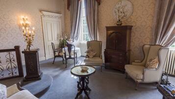 A room with a round table, a sofa, a cabinet, and a chair.