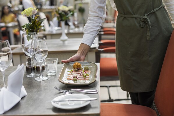 A dining table set with wine glasses, a water glass, and a plate with a food item.