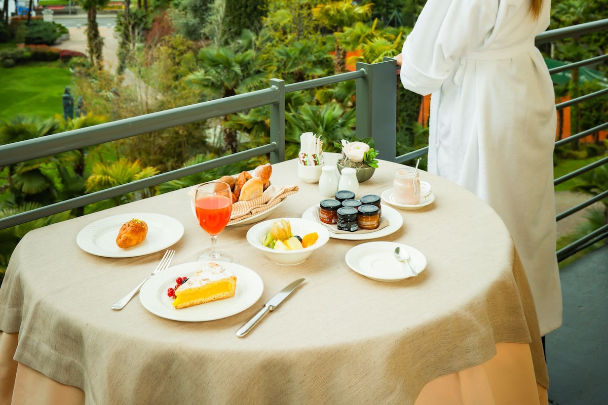 Una mesa dispuesta para el desayuno con una vista panorámica de una montaña y un lago.