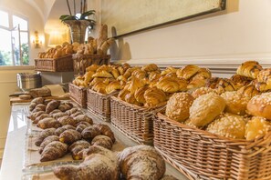 A bakery display with various types of bread and pastries.