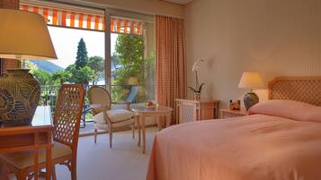 Une chambre d’hôtel avec un grand lit, une chaise, une petite table et une vue sur l’extérieur.
