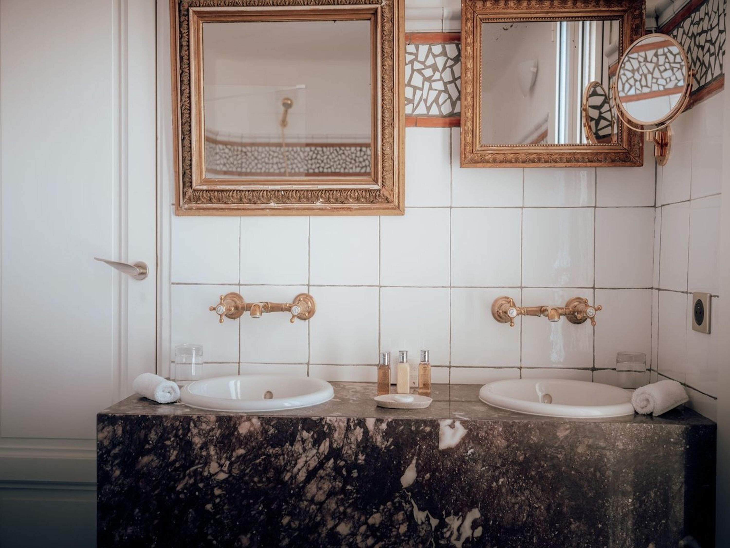 Een badkamer met twee wasbakken, een spiegel en een decoratief paneel.