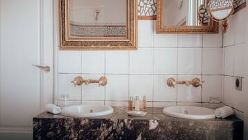 Een badkamer met twee wasbakken, een spiegel en een decoratief paneel.