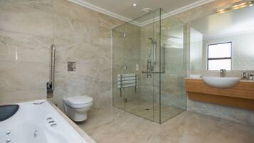 Une salle de bain moderne dotée d’une douche à parois de verre, d’une baignoire sur pieds et d’un meuble-lavabo.