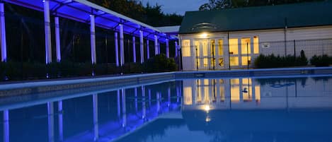 Una piscina al aire libre de temporada, sombrillas