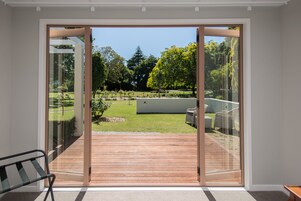 Una habitación moderna con un amplio ventanal corredero que da a un patio exterior.