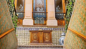 A staircase with ornate blue and yellow patterned tiles, wooden balustrades, and decorative metal railings. - La Casa de la Marquesa (Querétaro)