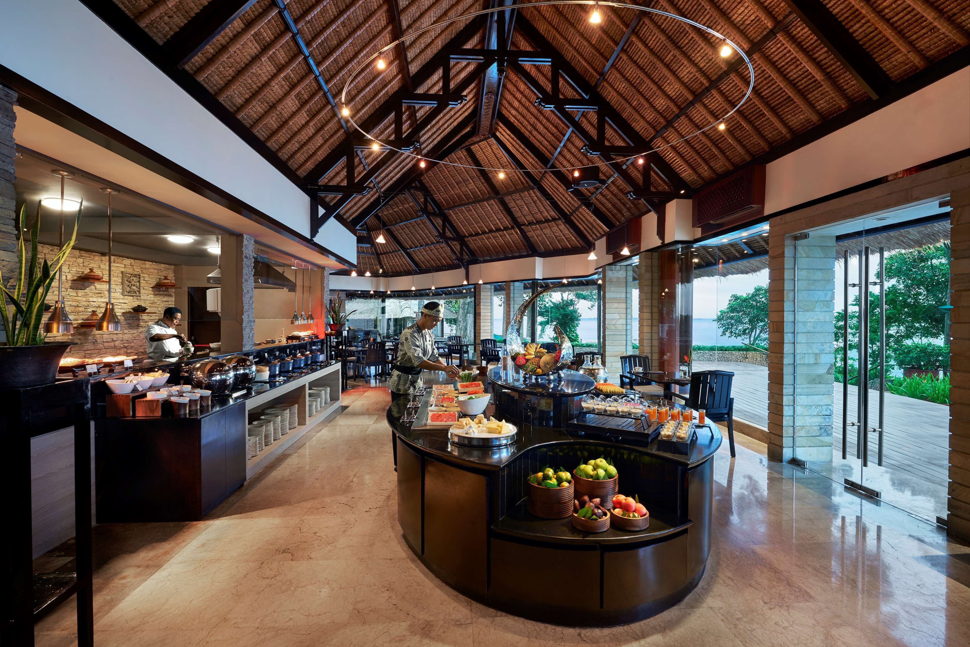 A spacious buffet area with a high ceiling and natural light, featuring a variety of food and drink options.