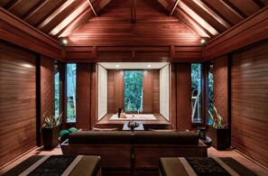 A wooden interior with a central seating area, large windows, and a ceiling with wooden beams. - Banyan Tree Bintan (Bintan)