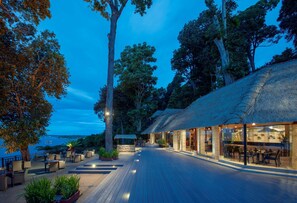 A resort with a wooden deck, outdoor seating, and a view of the sea. - Banyan Tree Bintan (Bintan)