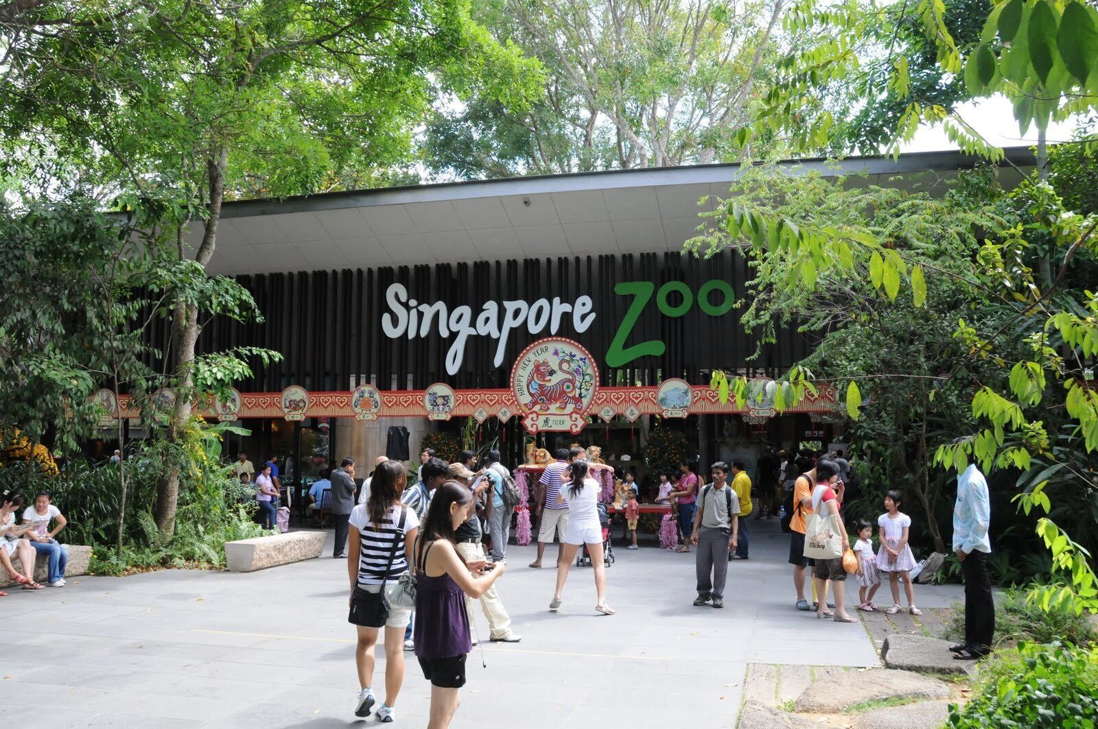 The Singapore Zoo entrance with people walking around.