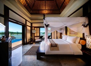 A spacious bedroom with a large bed, a view of a lake, and a balcony. - Banyan Tree Bintan (Bintan)