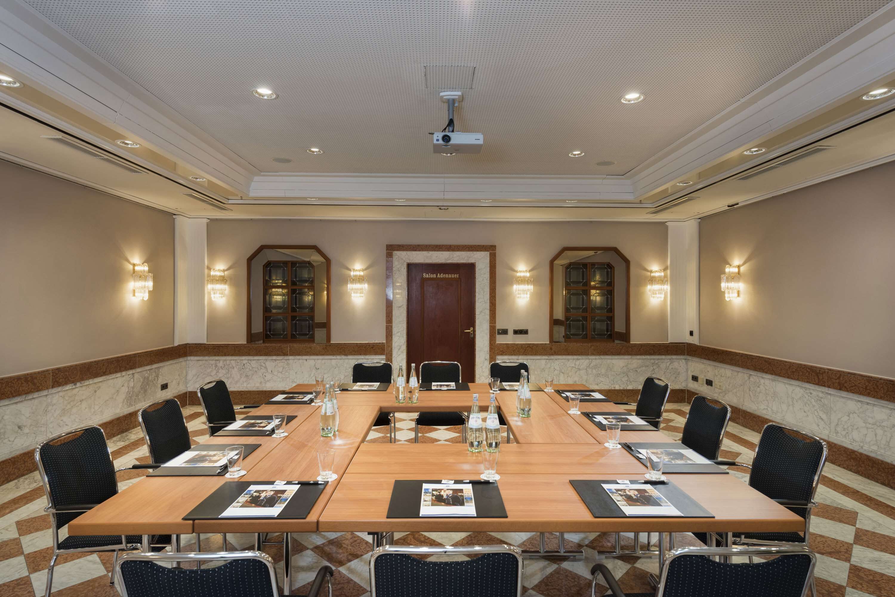 A conference room with a long table, chairs, and a projector.