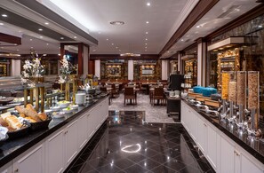 Un hall d’hôtel comprenant un espace buffet, des sièges et un grand miroir.