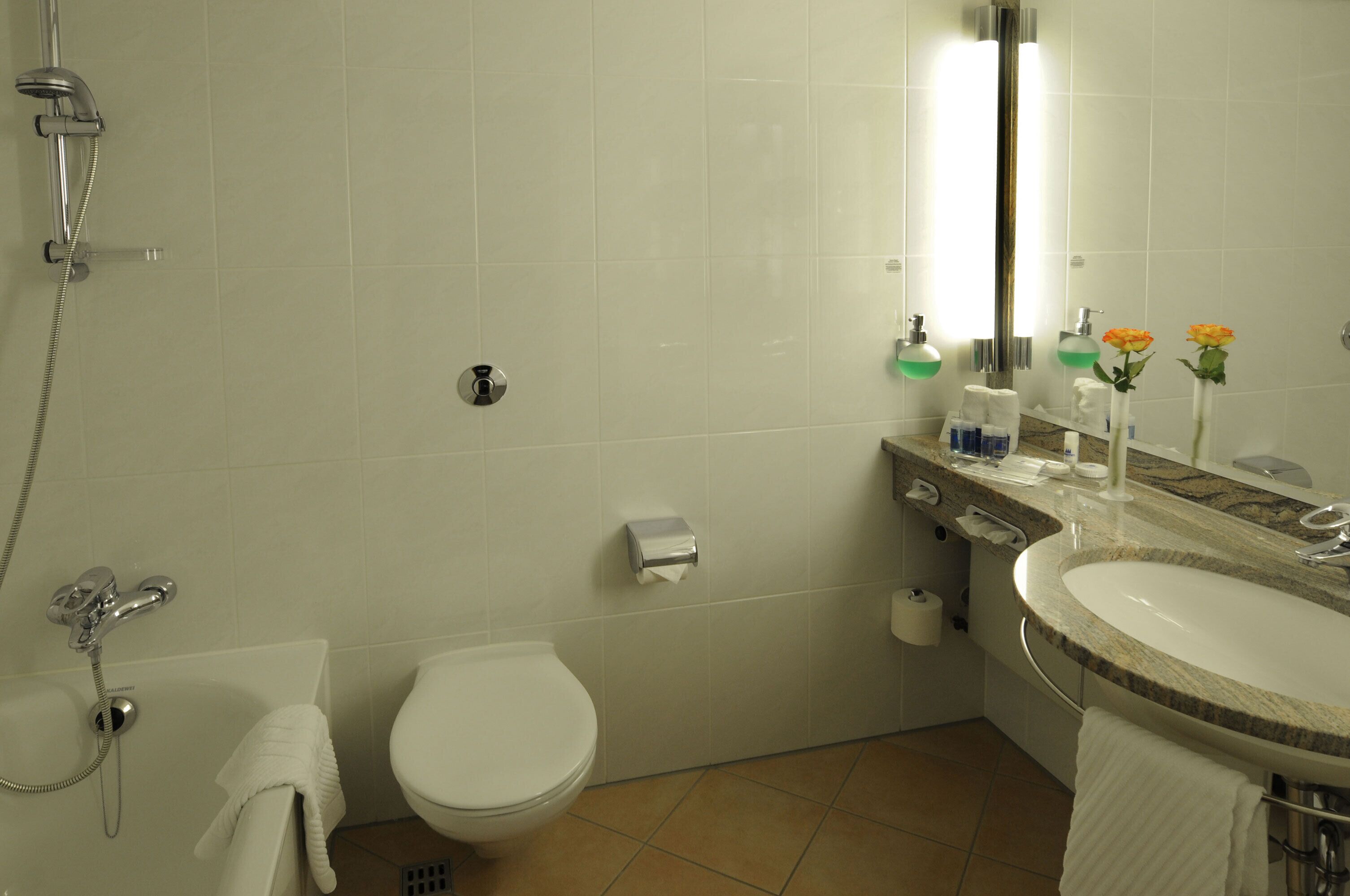 A bathroom with a toilet, sink, and shower.