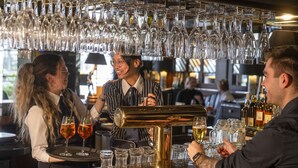 Zona de bar amb un cambrer servint a clients.