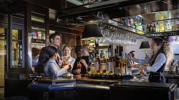 Un espace bar où un barman sert des boissons aux clients.