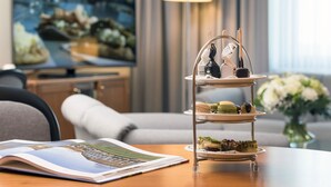 Un soporte de tres niveles para postres con pastelería sobre una mesa en una habitación de hotel.