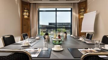 A conference room with a large table, chairs, a whiteboard, and a view of the airport.