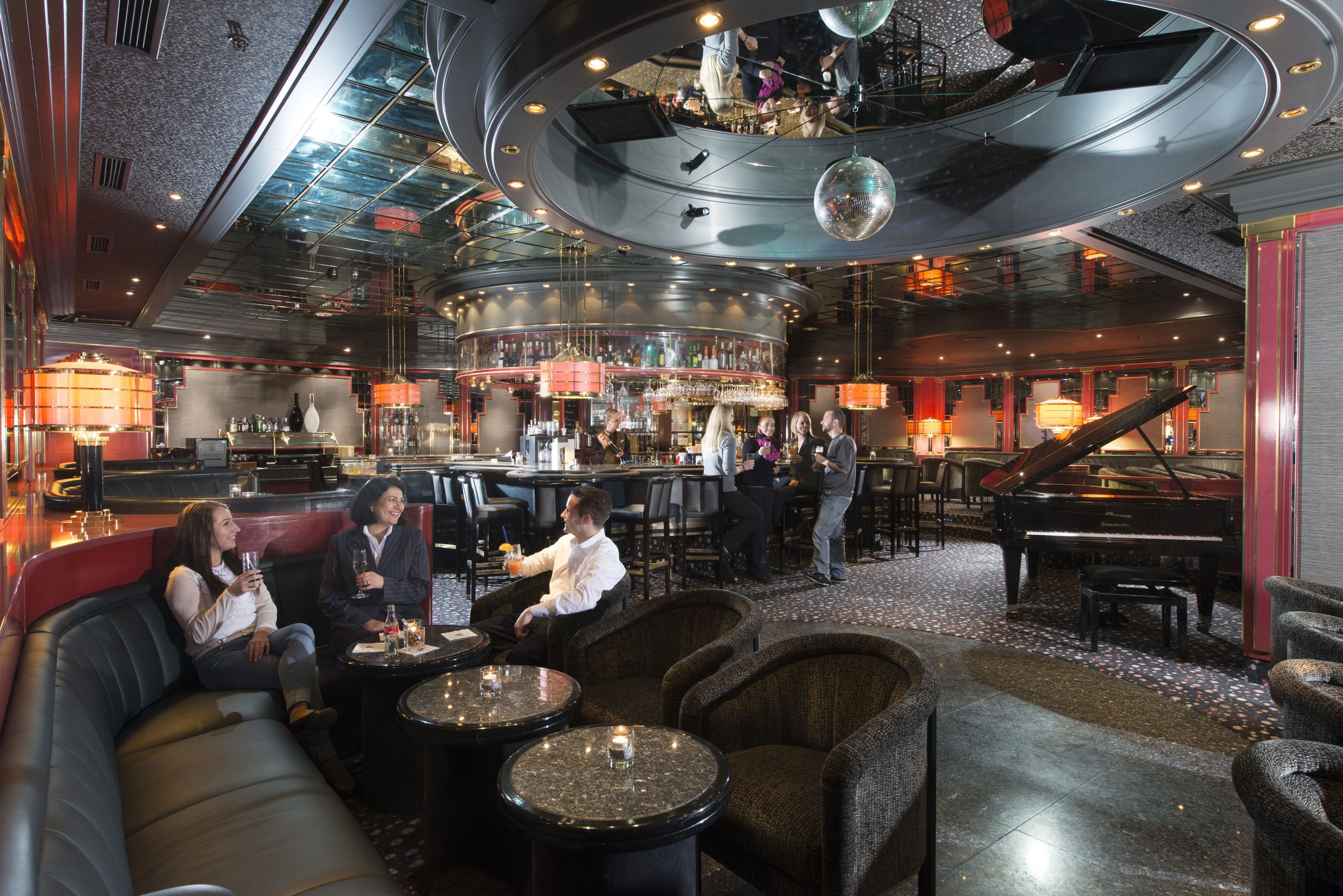 A bar area with seating, a piano, and a circular ceiling design.