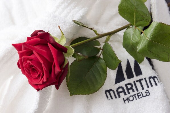 Una rosa roja sobre una toalla blanca con la leyenda "MARITIM HOTELS".