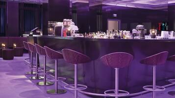 Angolo bar con sgabelli viola e bancone.