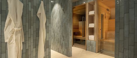 Um banheiro moderno com parede revestida, área de chuveiro em madeira e um closet amplo com toalhas dobradas.
